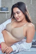 Woman wearing a beige bra and pink underwear in a casual setting with 'Bondelle' branding.
